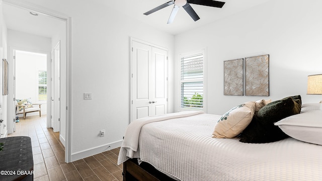 bedroom with dark hardwood / wood-style flooring, ceiling fan, and a closet