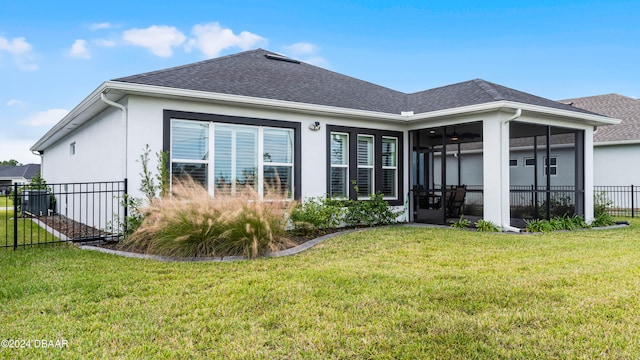 back of property featuring a lawn and a sunroom