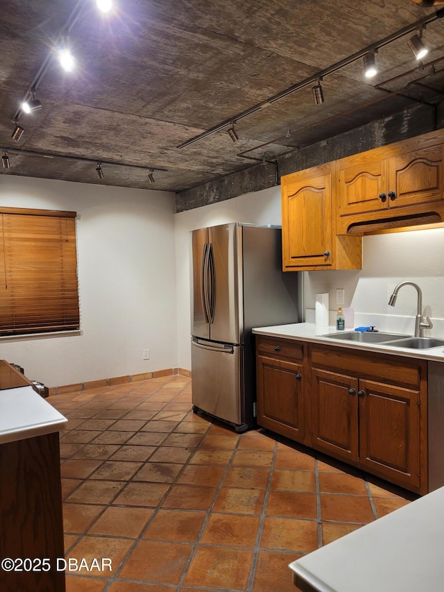 kitchen featuring sink, track lighting, and stainless steel refrigerator