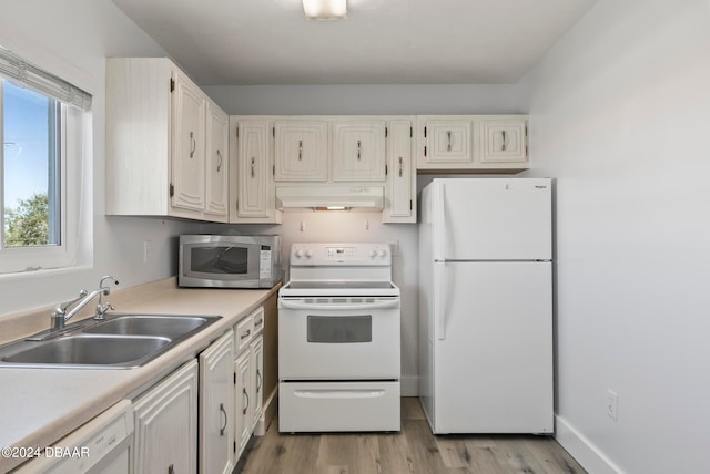 kitchen featuring light wood-type flooring, white appliances, and sink