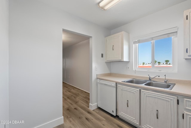 kitchen featuring white cabinets, dishwasher, sink, and light hardwood / wood-style flooring