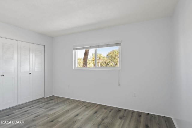 unfurnished bedroom with wood-type flooring and a closet