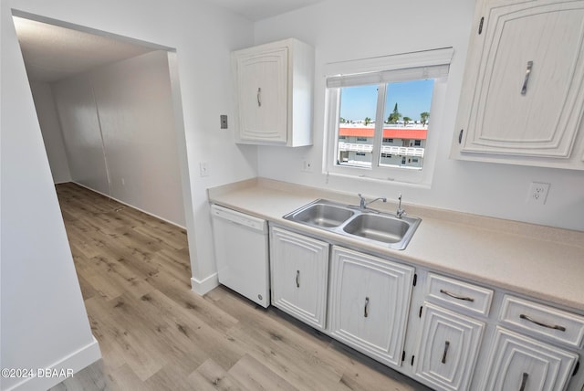 kitchen with dishwasher, light hardwood / wood-style floors, white cabinetry, and sink