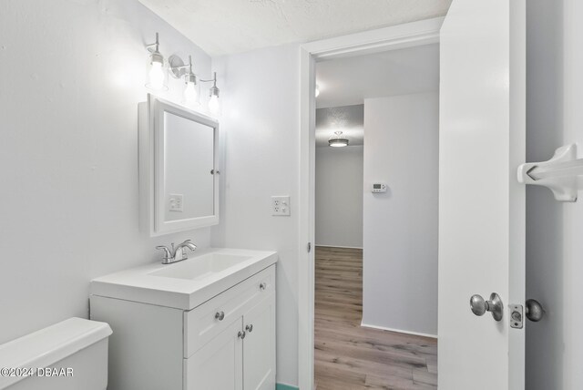 bathroom with hardwood / wood-style floors, vanity, and toilet