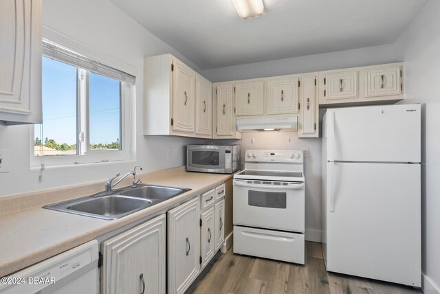 kitchen featuring sink, white appliances, and light hardwood / wood-style flooring