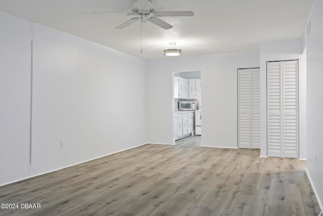 interior space featuring ceiling fan, light hardwood / wood-style floors, and a textured ceiling