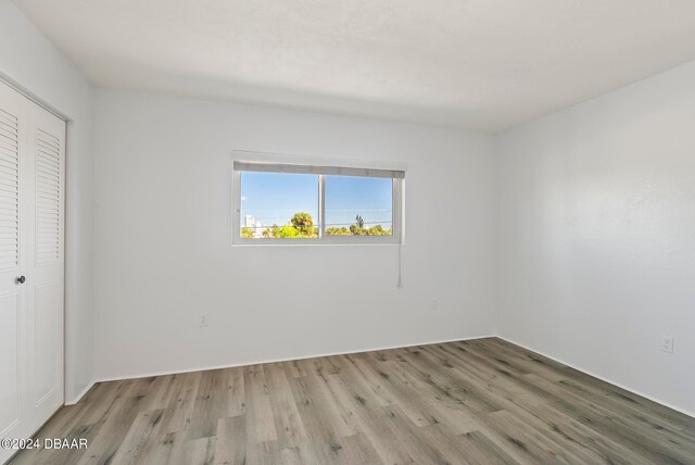 unfurnished bedroom with light hardwood / wood-style flooring and a closet