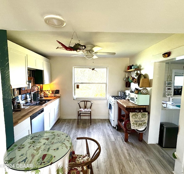 kitchen featuring butcher block counters, ceiling fan, sink, white appliances, and white cabinets