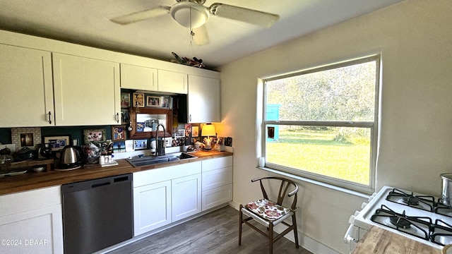 kitchen with stainless steel dishwasher, butcher block countertops, white gas stove, dark hardwood / wood-style flooring, and white cabinetry