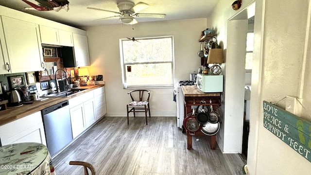 kitchen with sink, white cabinets, stainless steel dishwasher, and wood counters