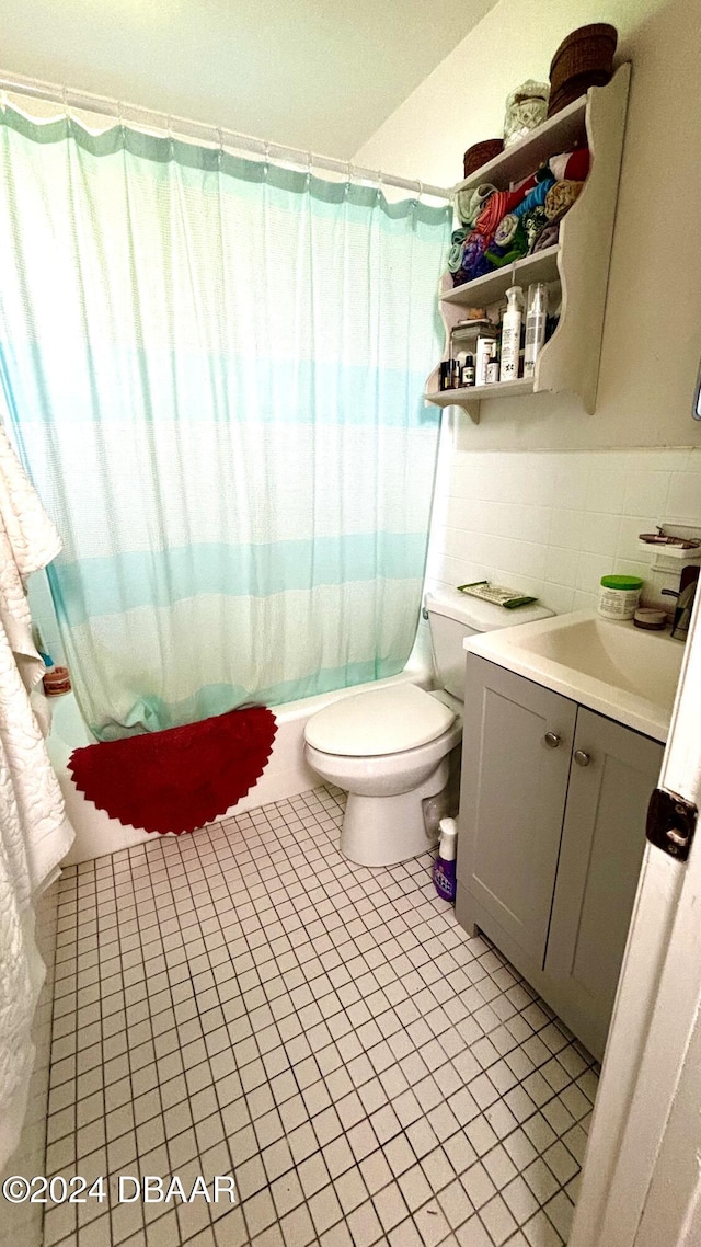 full bathroom with vanity, tile patterned floors, toilet, tile walls, and shower / tub combo