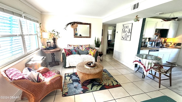 living room with light tile patterned floors, crown molding, and sink