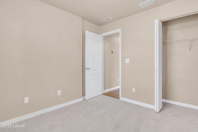 unfurnished bedroom with a closet, visible vents, baseboards, and carpet