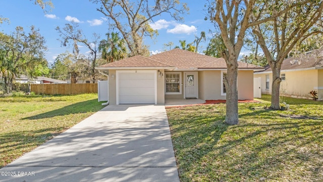 view of front of house featuring a front yard, fence, stucco siding, concrete driveway, and a garage