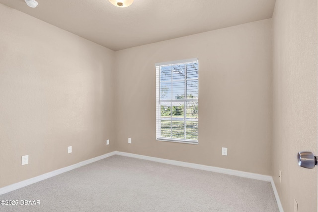 empty room featuring baseboards and carpet floors