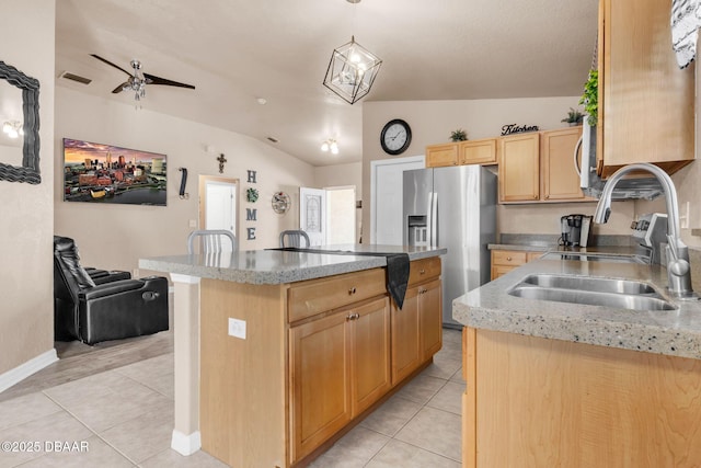 kitchen with visible vents, light brown cabinets, light tile patterned floors, stainless steel fridge, and a sink