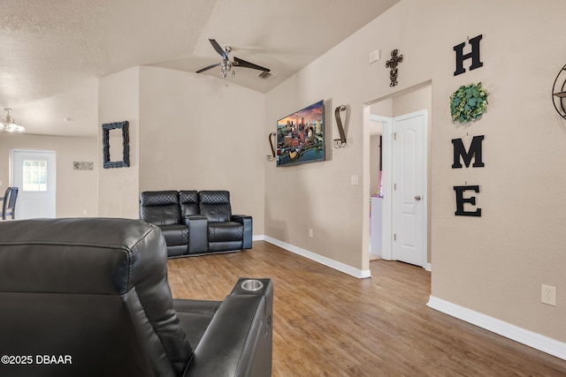 living area with wood finished floors, visible vents, baseboards, ceiling fan, and a textured ceiling