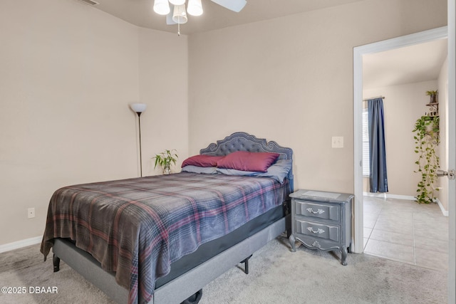 carpeted bedroom with tile patterned floors, baseboards, and ceiling fan