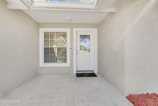 doorway to property featuring stucco siding