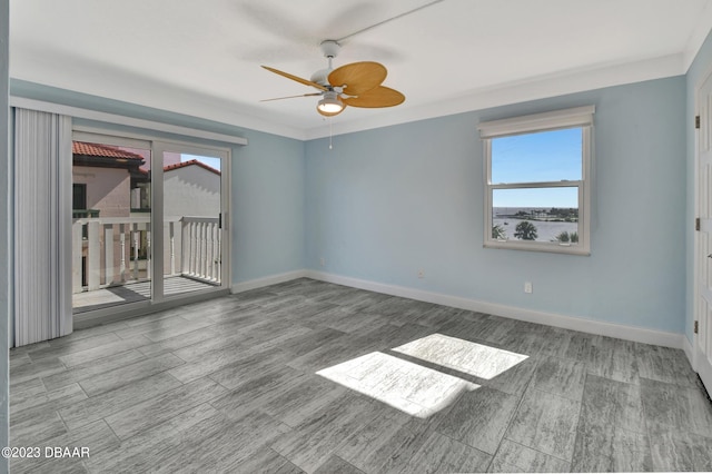 empty room featuring a wealth of natural light, wood-type flooring, and ceiling fan