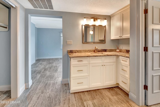 bathroom featuring vanity, hardwood / wood-style floors, and a textured ceiling