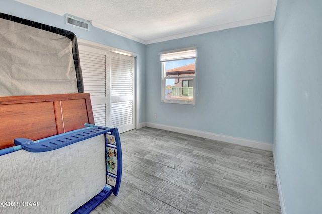 bedroom featuring a textured ceiling and ornamental molding