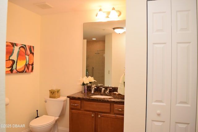full bathroom with vanity, a closet, a shower stall, and visible vents