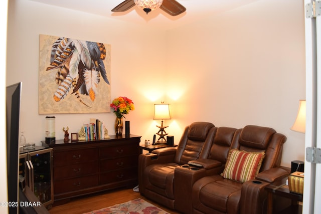 living room with a ceiling fan, wine cooler, and wood finished floors