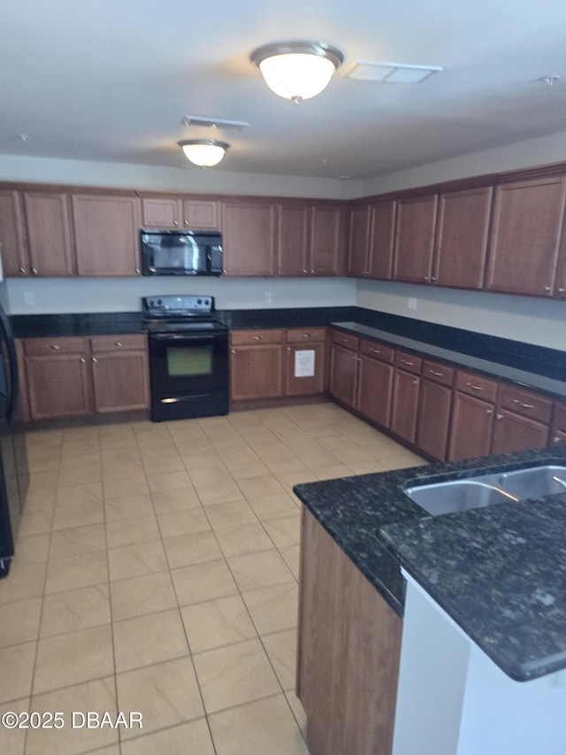 kitchen featuring black appliances and dark stone countertops