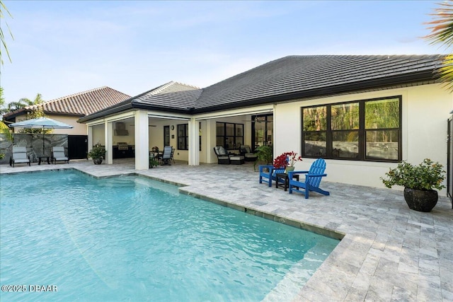 634 Woodbridge Dr, Ormond Beach, FL 32174 - rear view of property with a tile roof, an outdoor pool, a patio area, an outdoor hangout area, and stucco siding