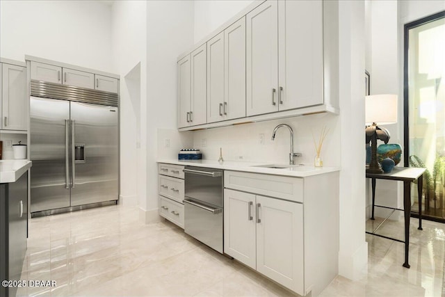 634 Woodbridge Dr, Ormond Beach, FL 32174 - kitchen with stainless steel appliances, a sink, light countertops, a high ceiling, and light marble finish floors