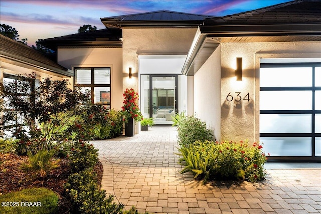 634 Woodbridge Dr, Ormond Beach, FL 32174 - exterior entry at dusk with stucco siding