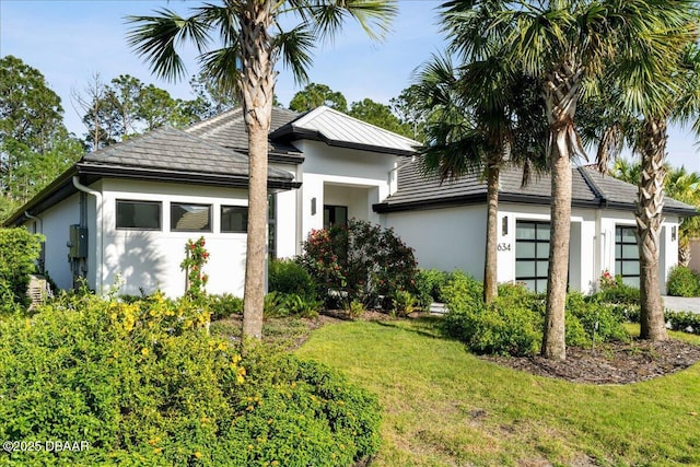 634 Woodbridge Dr, Ormond Beach, FL 32174 - view of front facade featuring stucco siding, a front yard, and an attached garage