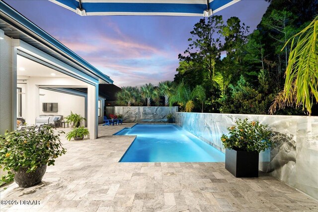 634 Woodbridge Dr, Ormond Beach, FL 32174 - pool at dusk with a patio area and a fenced backyard
