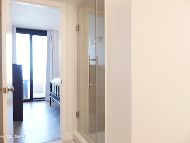 bathroom with a shower stall and wood finished floors