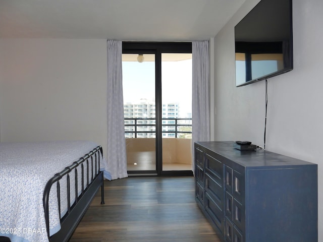 bedroom with expansive windows, dark wood finished floors, and access to exterior