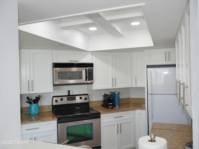 kitchen with light stone counters, white cabinetry, and appliances with stainless steel finishes
