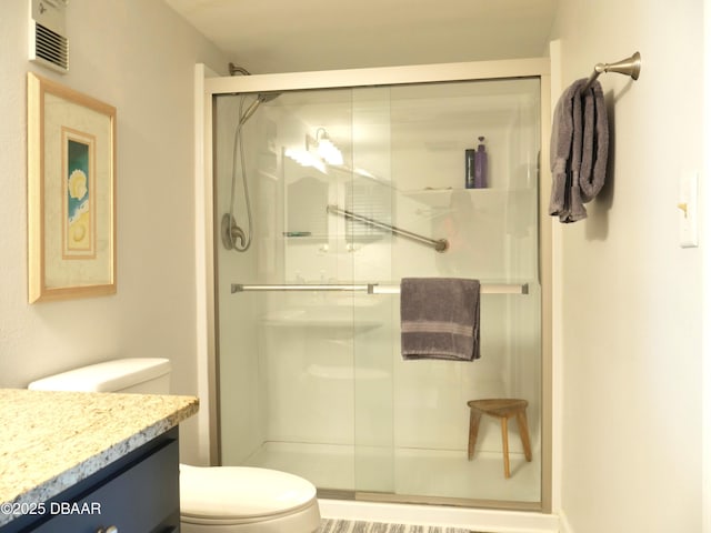 full bathroom featuring toilet, visible vents, a shower stall, and vanity