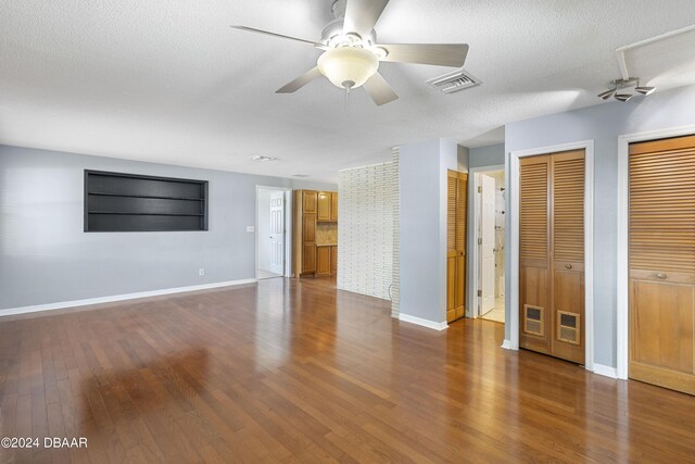 interior space with a textured ceiling, hardwood / wood-style flooring, and ceiling fan