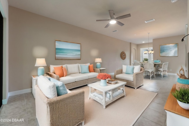 living room featuring ceiling fan with notable chandelier and light tile patterned floors