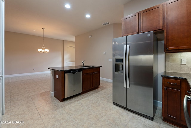 kitchen featuring an inviting chandelier, tasteful backsplash, appliances with stainless steel finishes, decorative light fixtures, and dark stone countertops