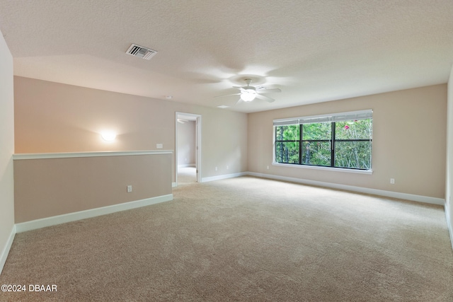 empty room with a textured ceiling, light carpet, and ceiling fan