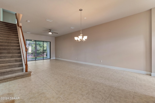 spare room featuring ceiling fan with notable chandelier and light tile patterned floors