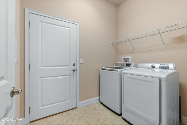 washroom with washer and clothes dryer and light tile patterned flooring