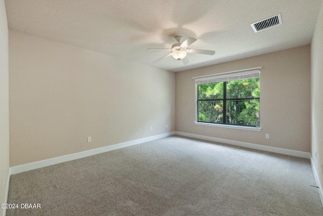 carpeted empty room with a textured ceiling and ceiling fan