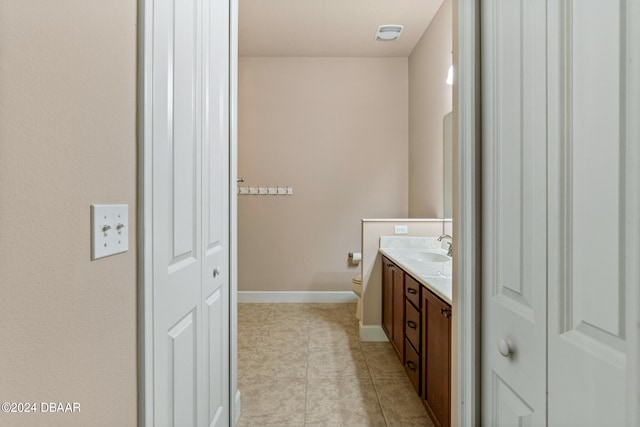 bathroom with tile patterned flooring, vanity, and toilet