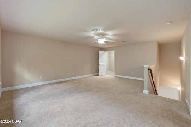 spare room with ceiling fan and light colored carpet