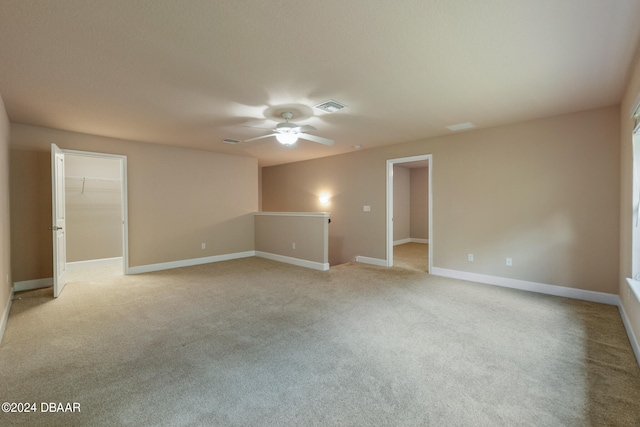 empty room featuring light colored carpet and ceiling fan