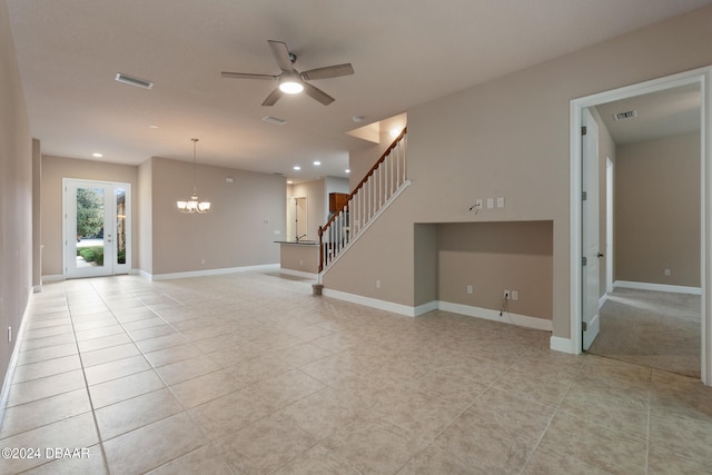 unfurnished living room featuring ceiling fan with notable chandelier and light tile patterned floors