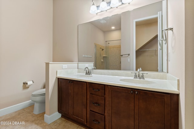 bathroom featuring vanity, tile patterned flooring, toilet, and a tile shower